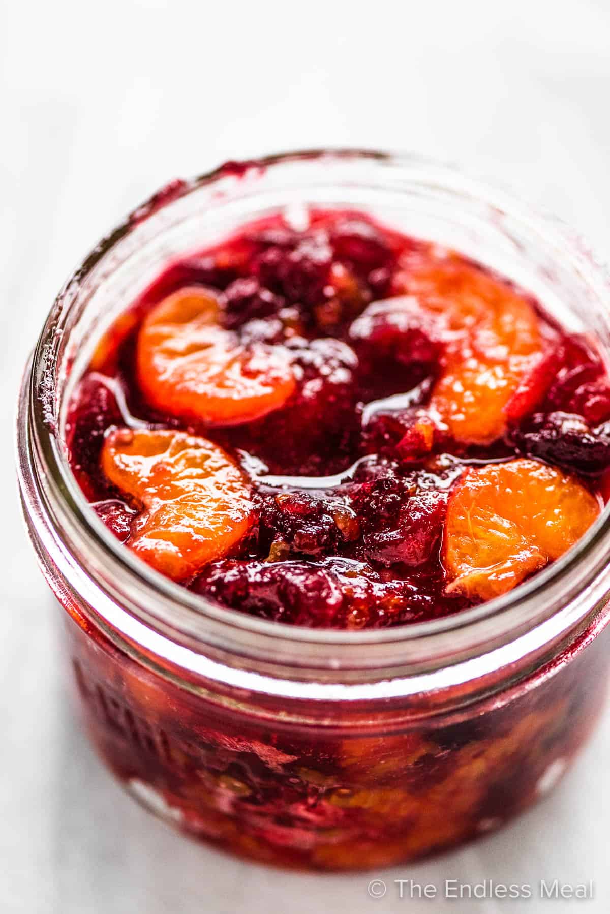 A mason jar with this cranberry sauce with mandarin oranges recipe ready for gifting. 
