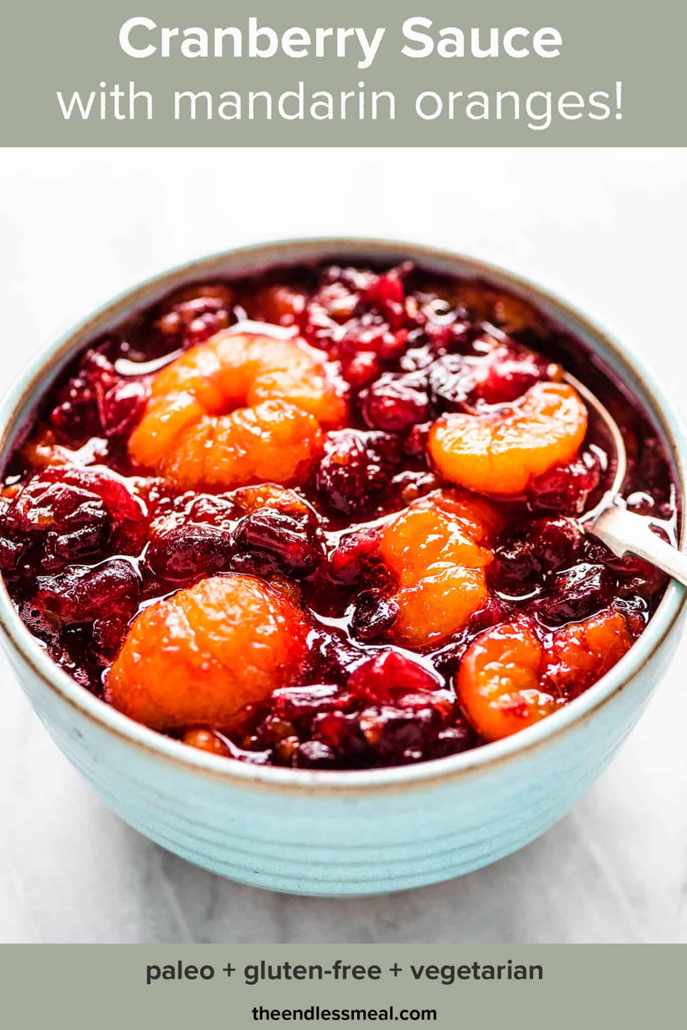 Cranberry sauce with whole mini mandarin oranges in a blue bowl with the recipe title on top of the picture.