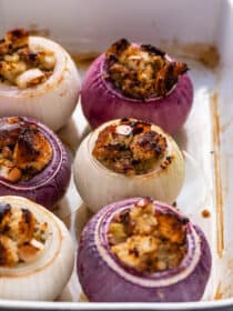 a close up of Stuffed Onions in a baking dish