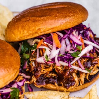 A pulled chicken sandwich on a lunch plate.