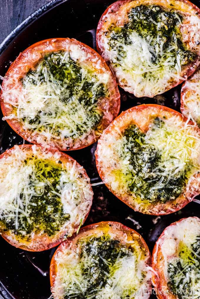 Pesto Stuffed Roasted Tomatoes are a must make side dish/ appetizer. The hollowed out tomato halves are stuffed with an easy to make, garlicky pesto then roasted until the cheese melts and the tomatoes are soft. They're delicious! | vegetarian + gluten-free + keto | #theendlessmeal #tomatoes #pesto #stuffedtomatoes #keto #glutenfree #vegetarian 