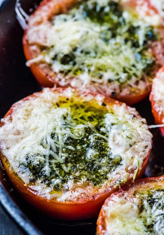 Pesto Stuffed Roasted Tomatoes are a must make side dish/ appetizer. The hollowed out tomato halves are stuffed with an easy to make, garlicky pesto them roasted until the cheese melts and the tomatoes are soft. They're delicious! | vegetarian + gluten-free + keto | #theendlessmeal #tomatoes #pesto #stuffedtomatoes #keto #glutenfree #vegetarian