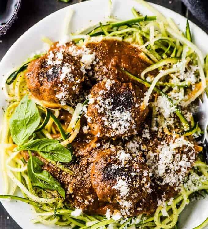 A plate of the best spaghetti and meatballs over zoodles with a little parmesan cheese sprinkled over the top.