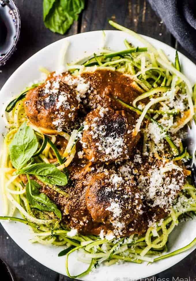 A plate of the best spaghetti and meatballs over zoodles with a little parmesan cheese sprinkled over the top.