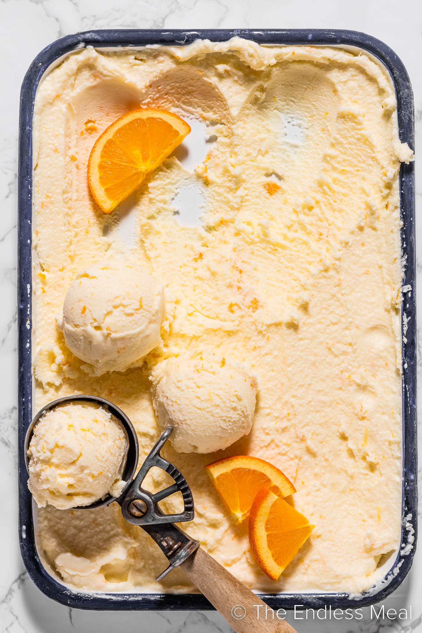 Orange Sherbet with an ice cream scoop.