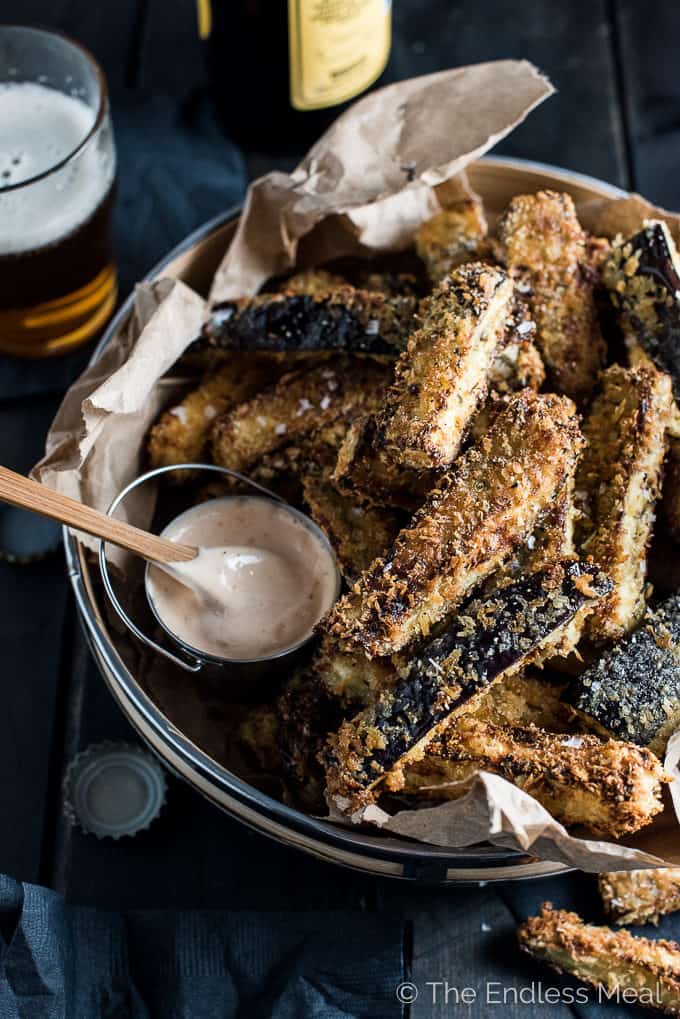 Eggplant fries piled high on a plate with a side of chipotle mayo.