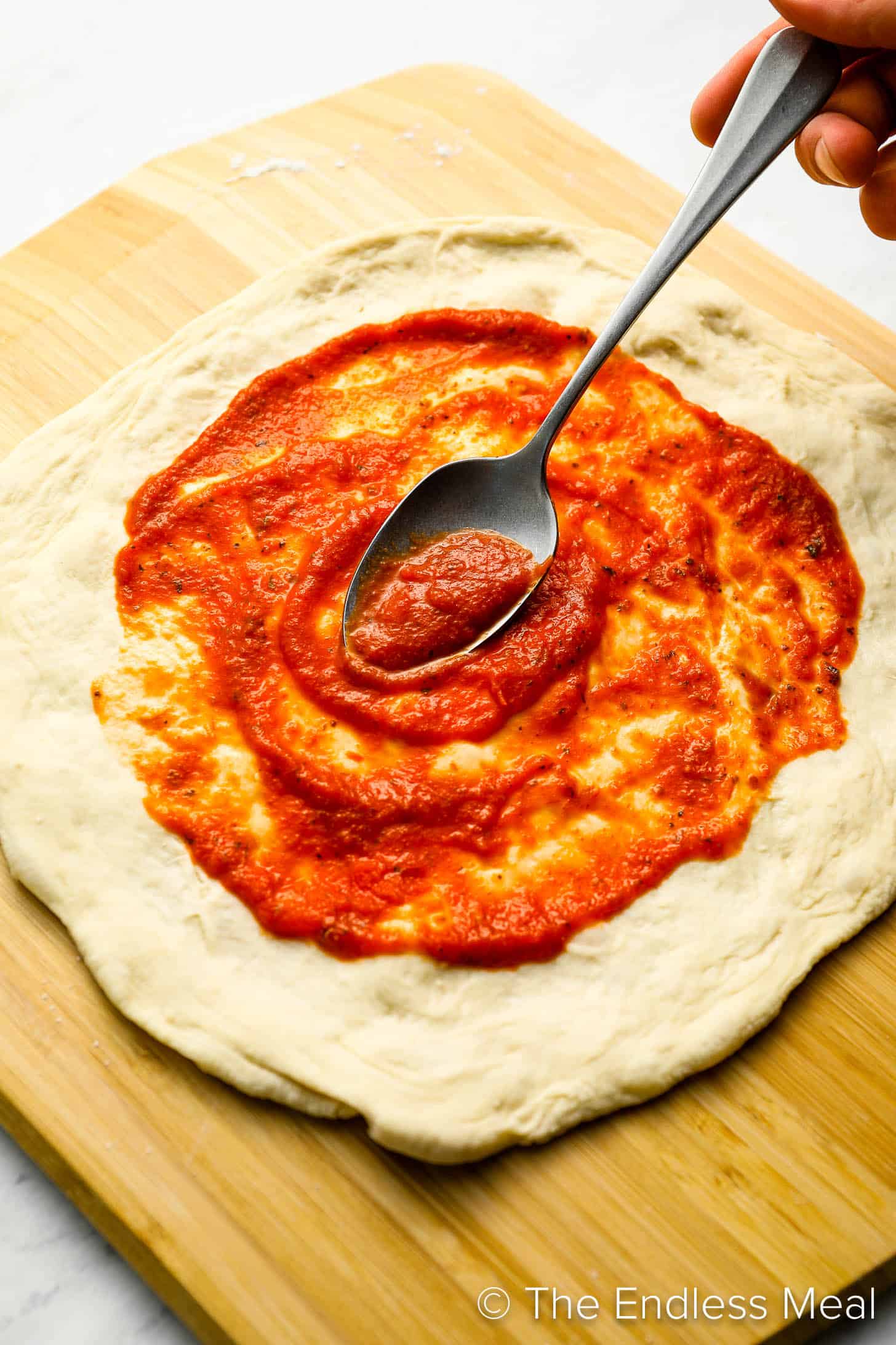Pizza sauce being spread on our Pizza Dough.