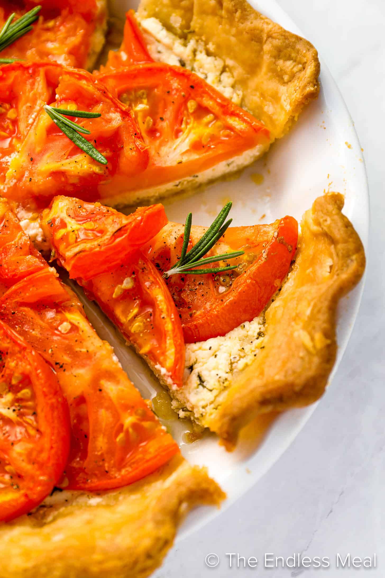 A slice of Tomato Tart in a pie pan