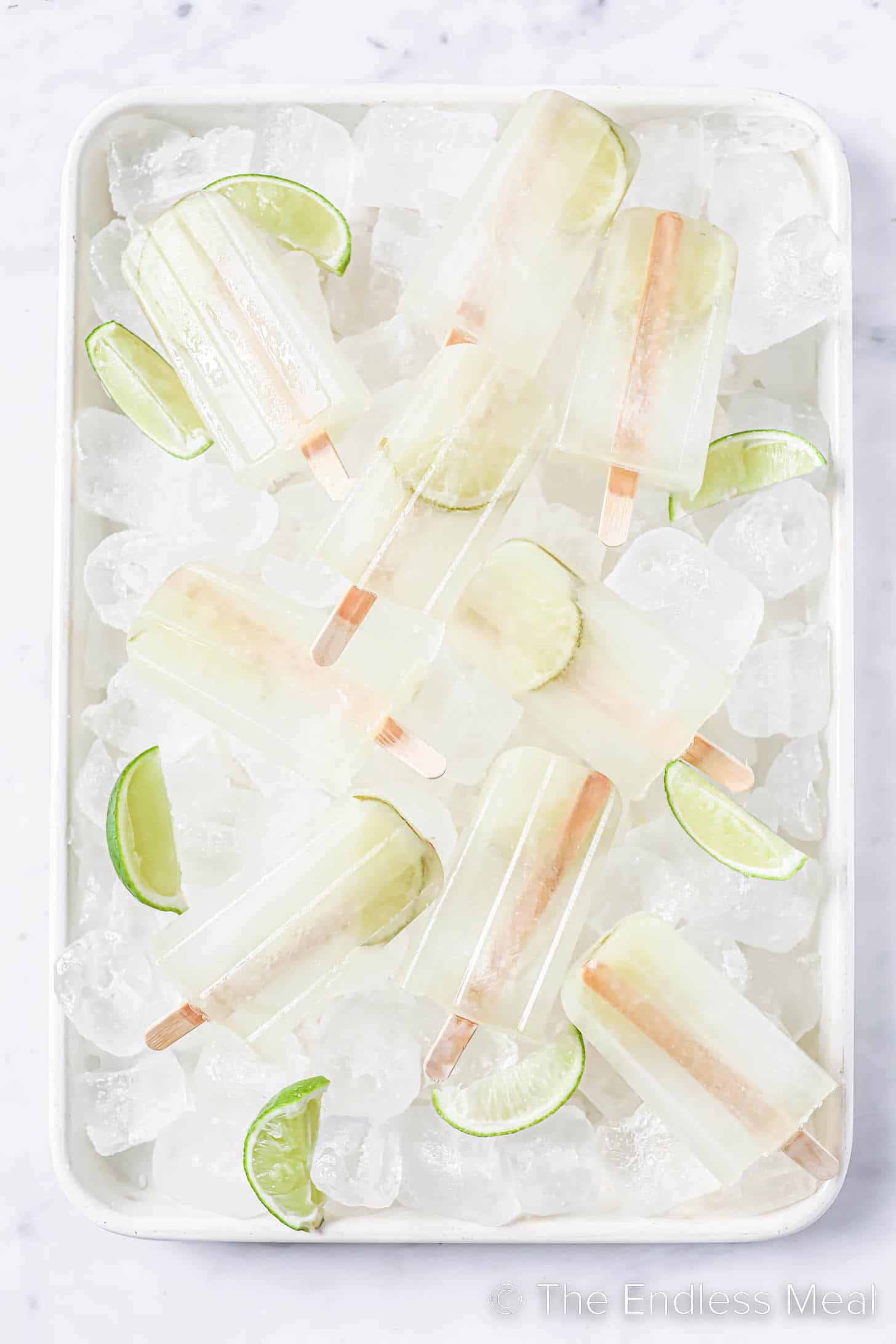 Margarita Popsicles on ice with limes.