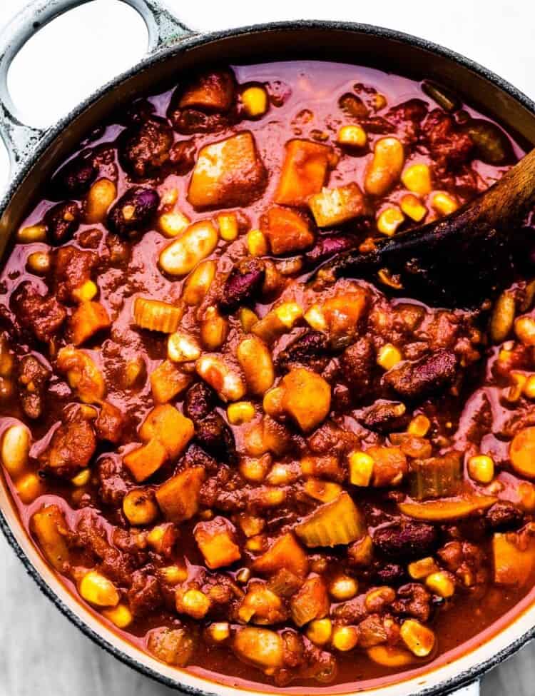 Looking down on a pot of easy vegetarian chili with a wooden spoon in it.