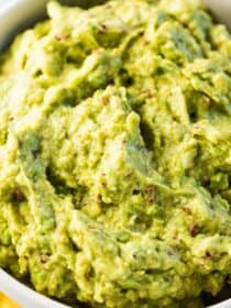 A close up of chipotle guacamole in white bowl.