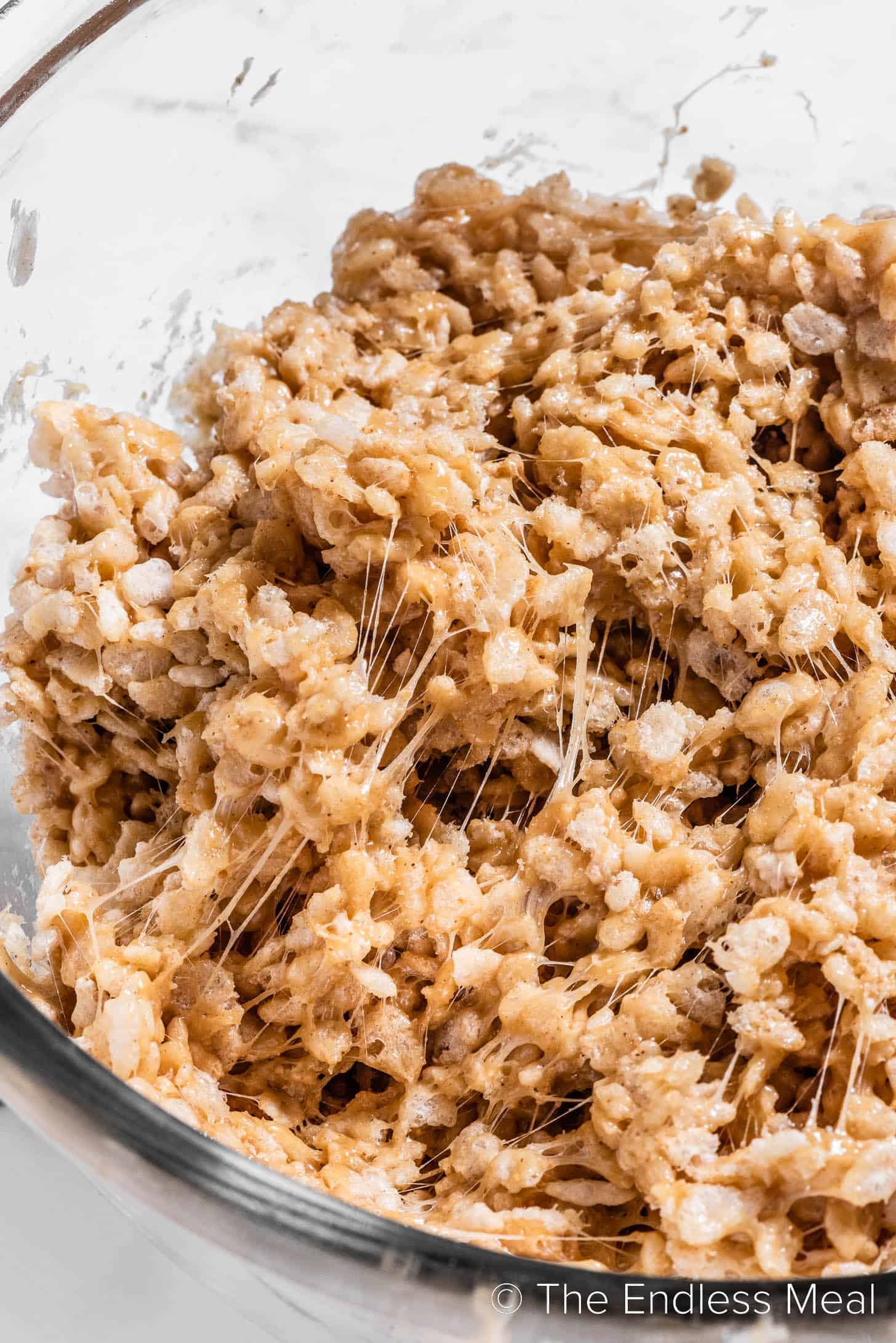 Mixing Peanut Butter Rice Krispie Treats in a glass bowl