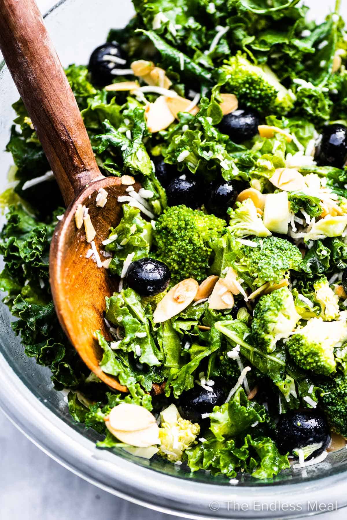 A close up of kale broccoli salad in a salad bowl.