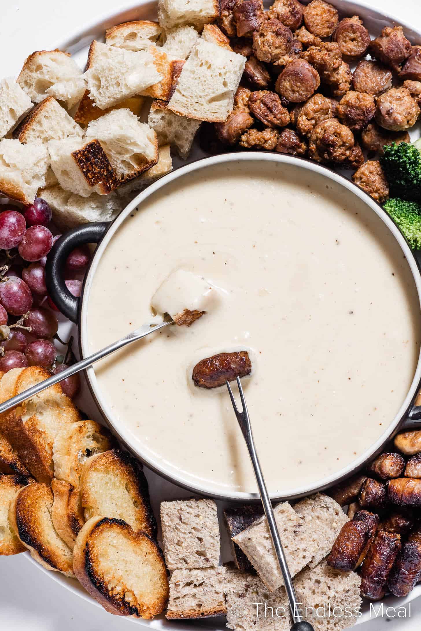 Gruyere Cheese Fondue in a pot surrounded by bread and dippers