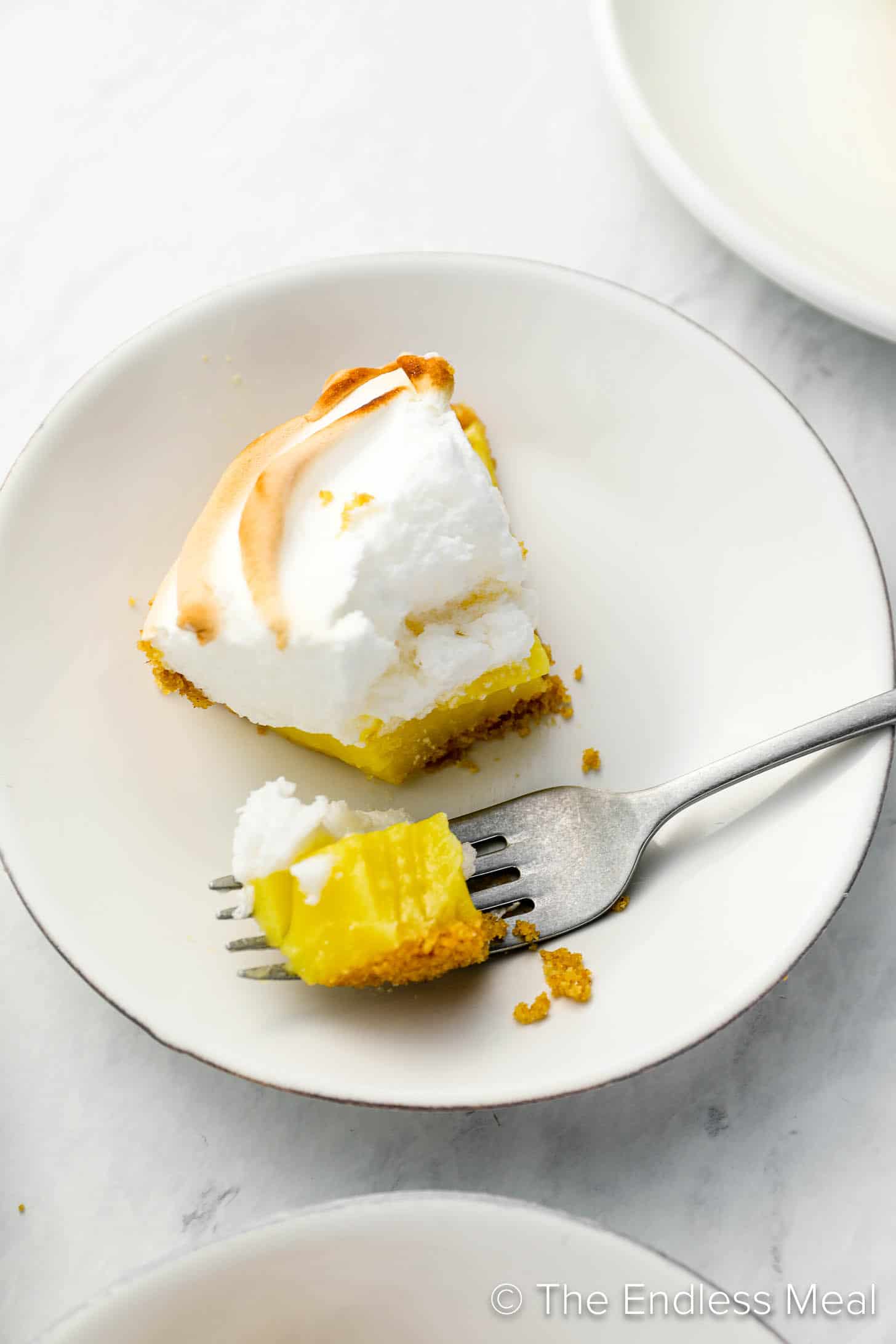 a fork taking a bite of Easy Lemon Meringue Pie on a plate