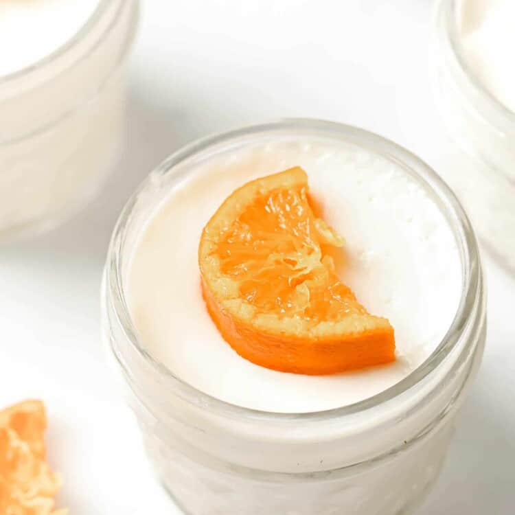 Orange Blossom Panna Cotta in a glass mason jar topped with a candied mandarin orange