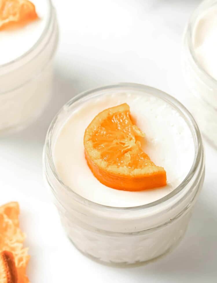 Orange Blossom Panna Cotta in a glass mason jar topped with a candied mandarin orange