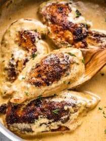 Chicken lazone in a pan with a wooden spoon,