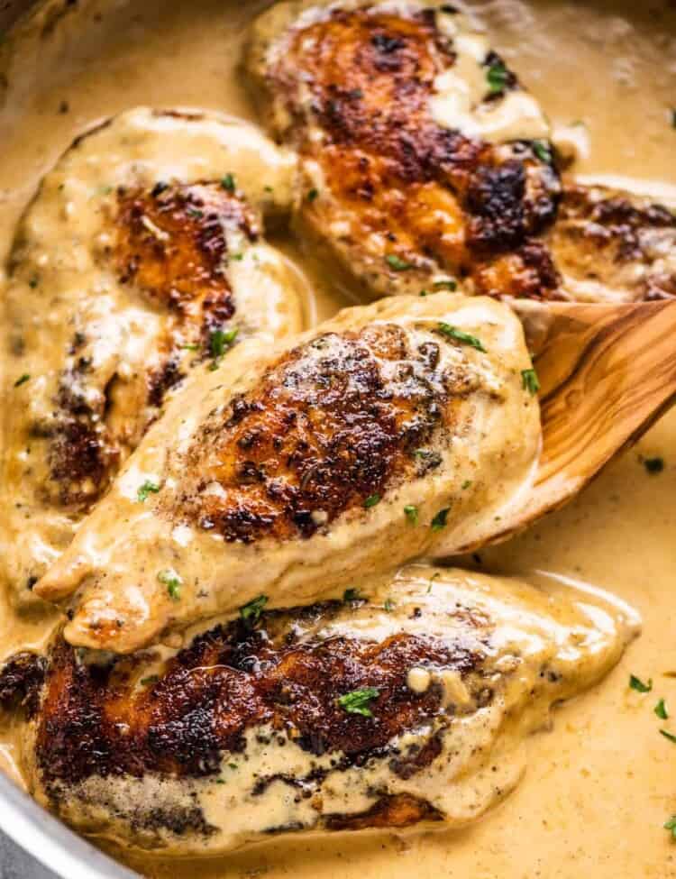 Chicken lazone in a pan with a wooden spoon,