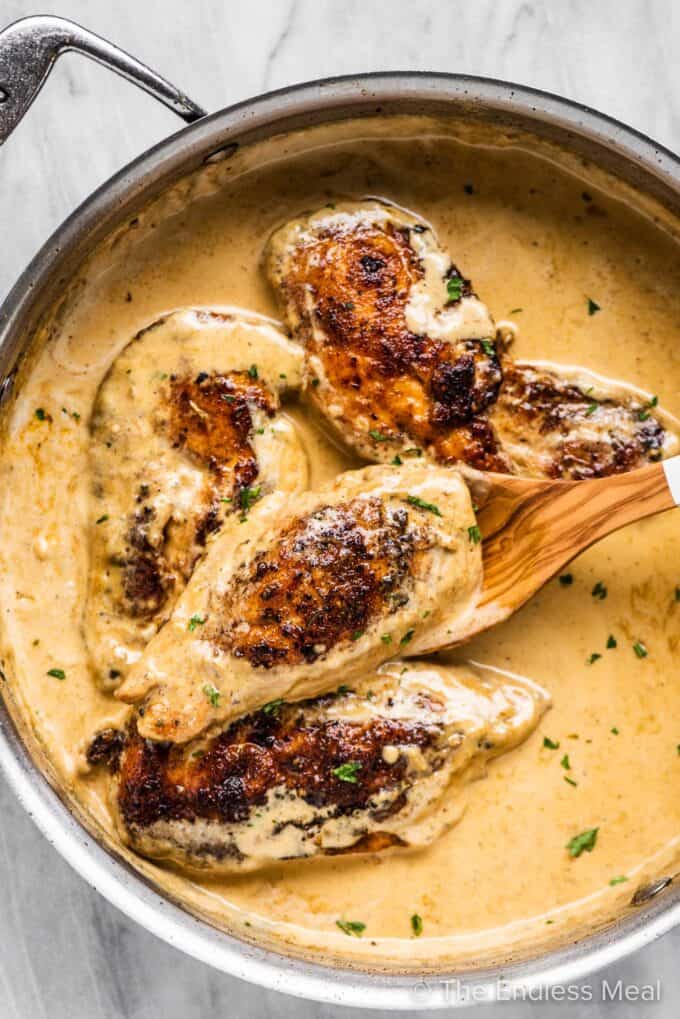Chicken lazone in a pan with a creamy sauce.