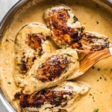 Chicken lazone in a pan with a creamy sauce.