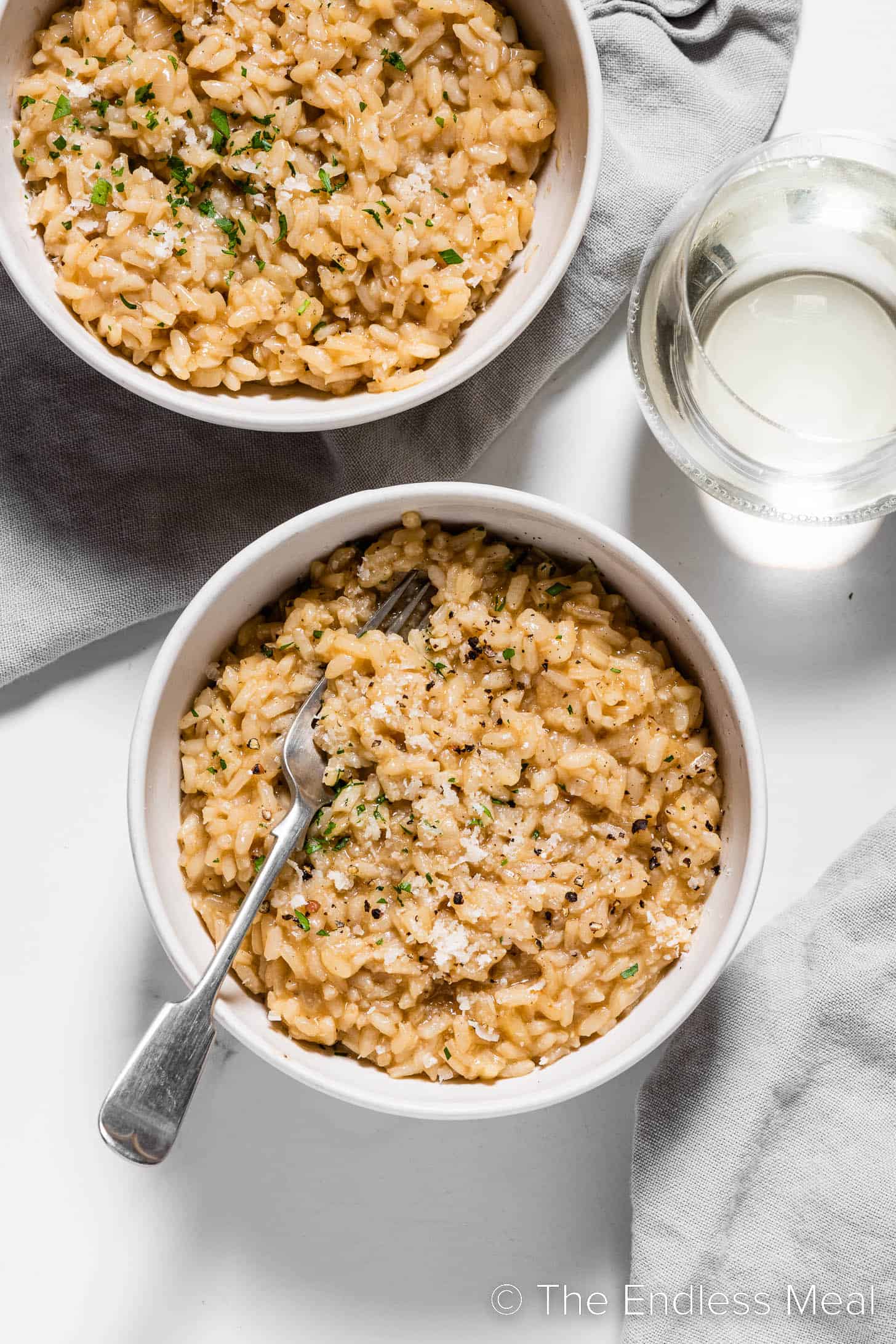 This easy risotto recipe n the table with a glass of wine