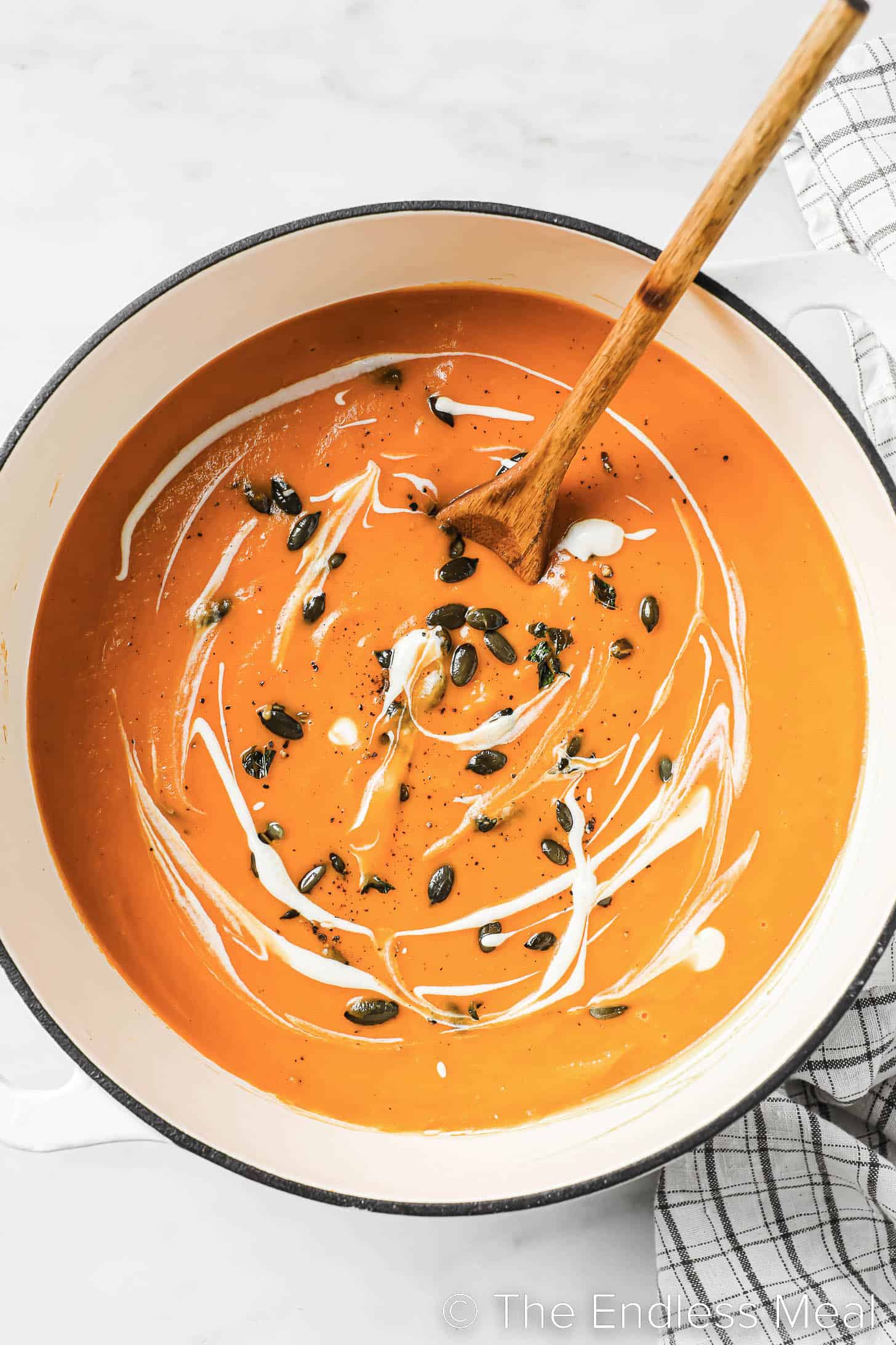 a wooden spoon stirring a pot of Spicy Butternut Squash Soup
