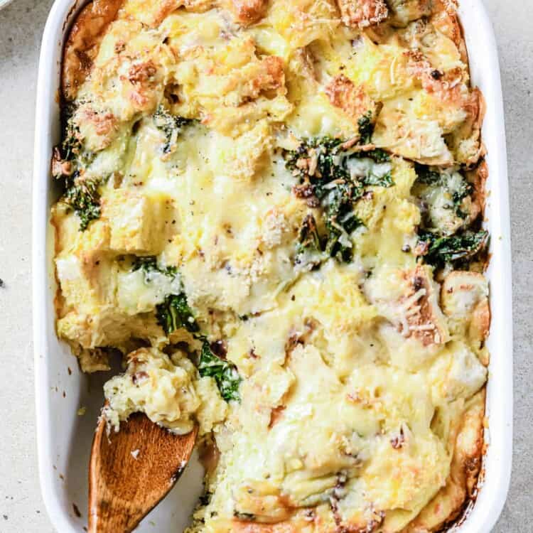 Vegetarian Cheese Strata in a casserole dish with a serving spoon.