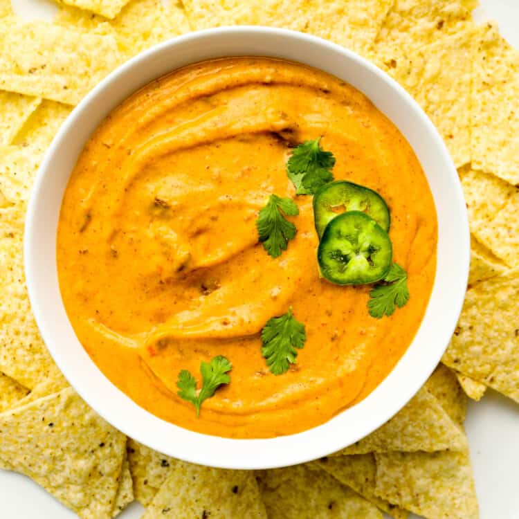 Chili Cheese Dip in a bowl surrounded by corn chips