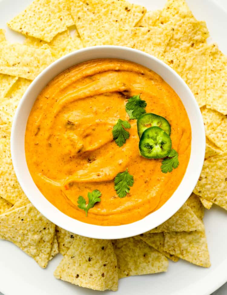 Chili Cheese Dip in a bowl surrounded by corn chips