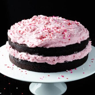 A Chocolate Beet Cake on a cake stand with pink frosting