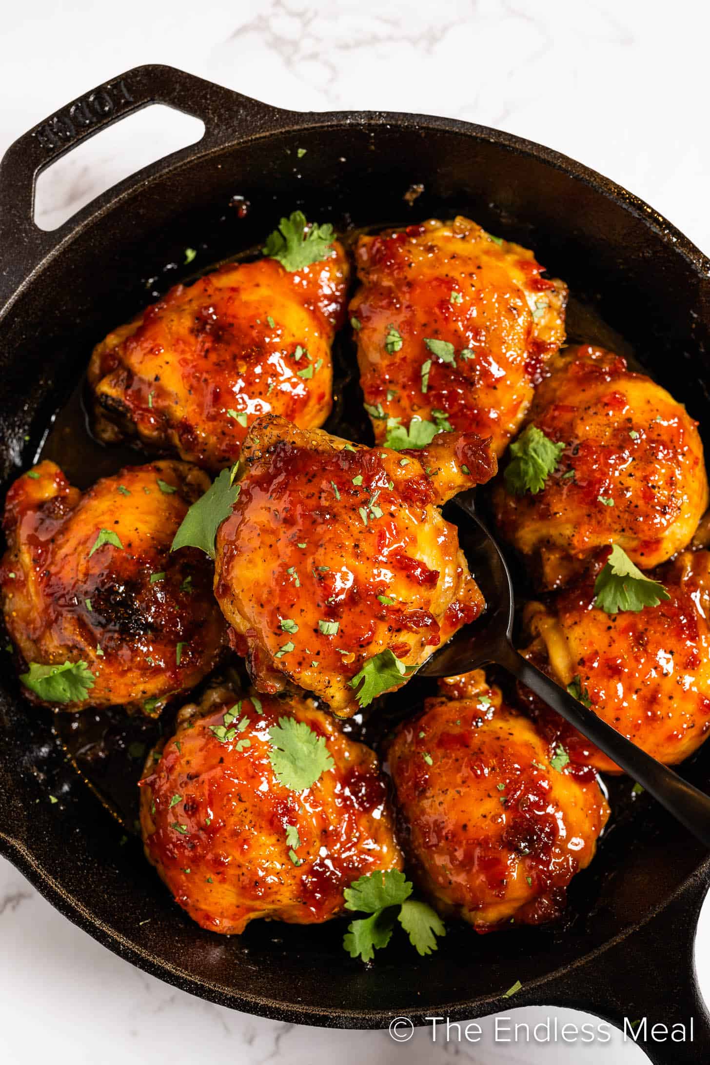 Harissa Honey Chicken in a cast iron pan.