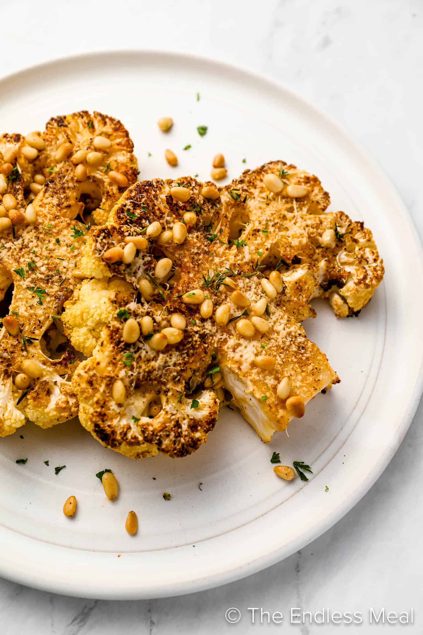 A close up of Cauliflower Steaks on a white plate