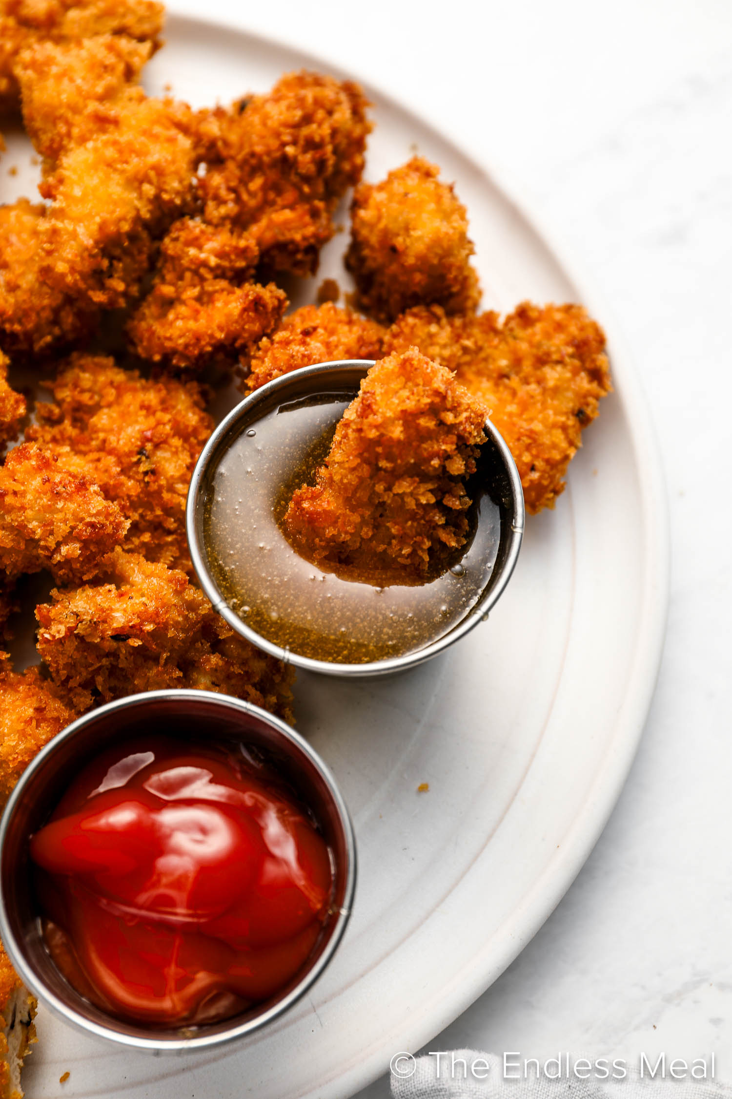 Popcorn Chicken being dipped into sauce