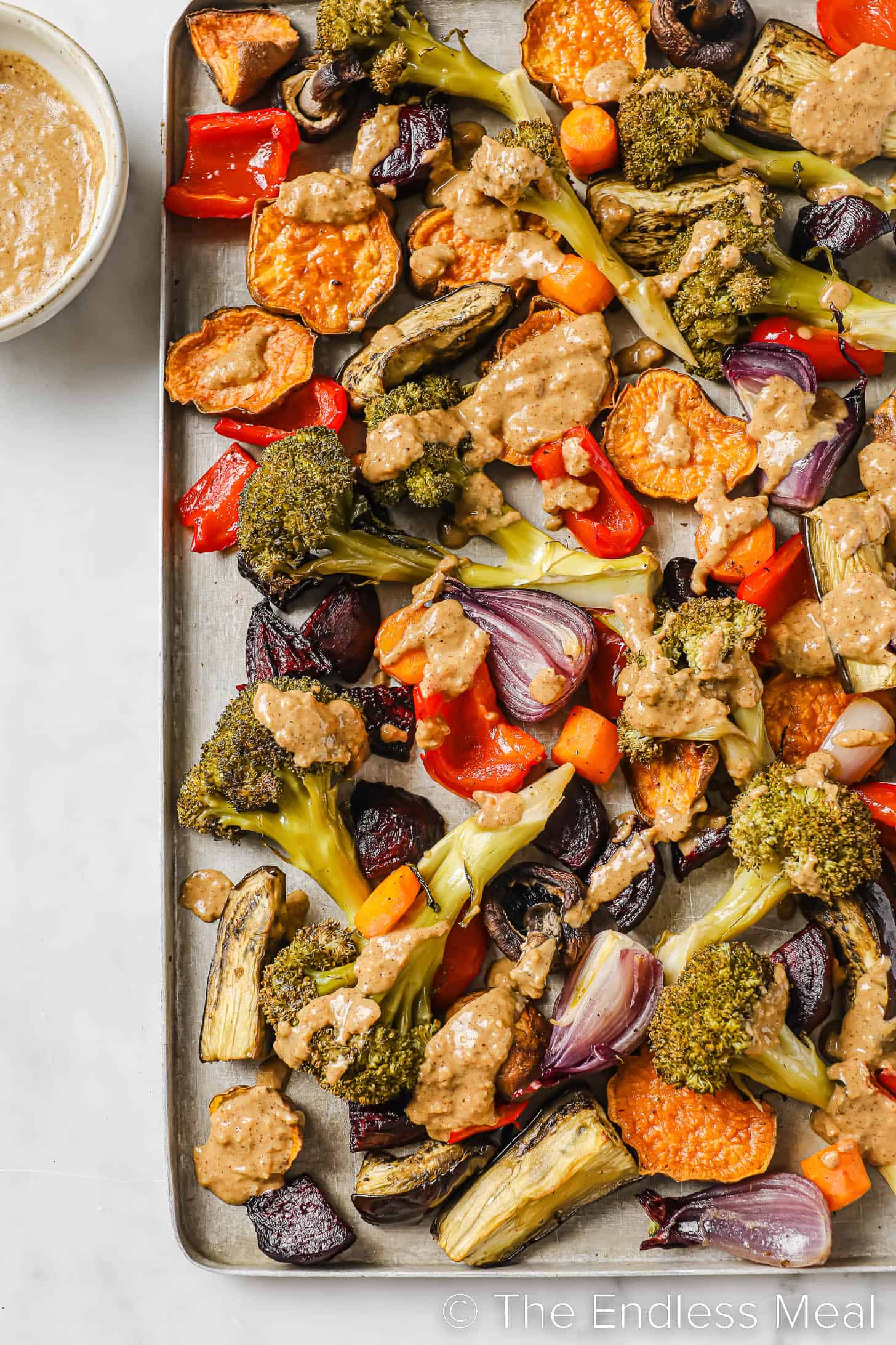 roasted veggie dinner recipe with almond satay sauce drizzled on top