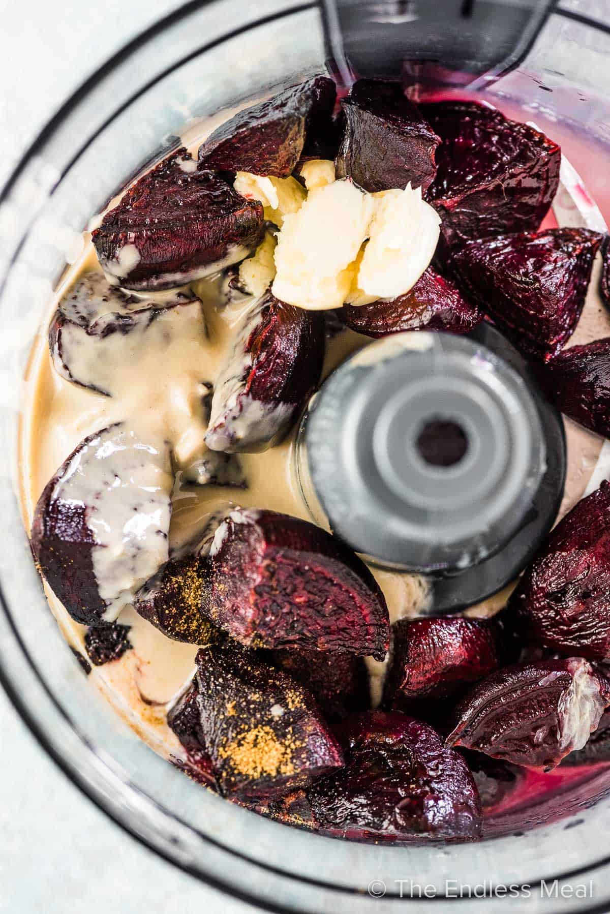 All the ingredients to make this roasted beet hummus in a food processor.