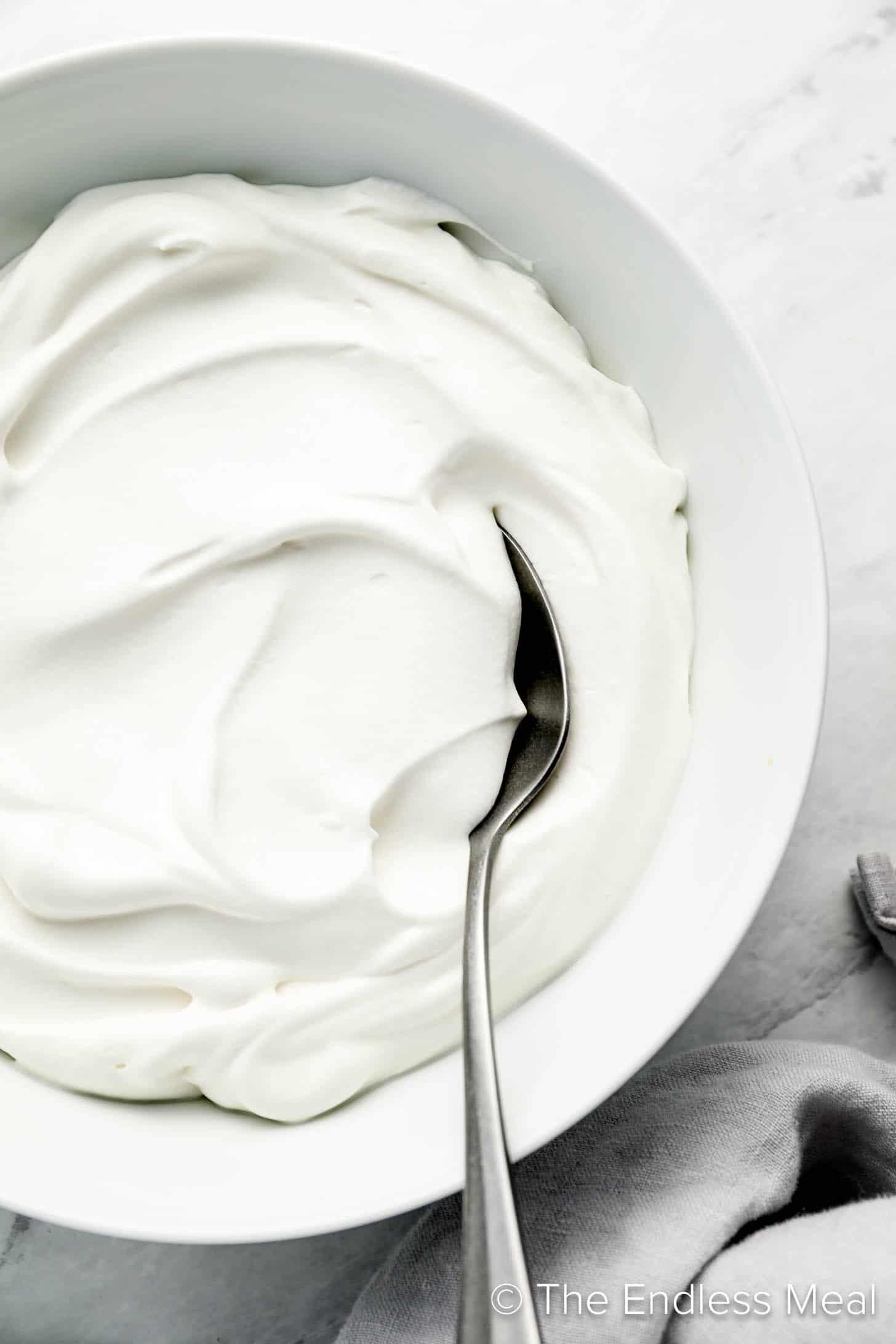 Coconut Whipped Cream in a bowl with a spoon