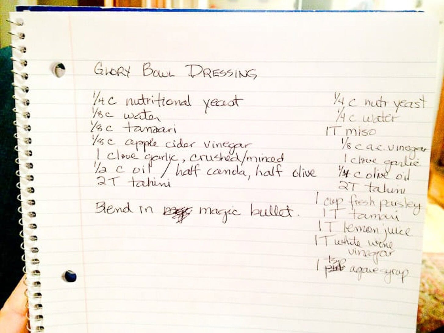 A handwritten recipe for Glory Bowl Dressing in a spiral notebook, with ingredients like nutritional yeast, water, tamari, and tahini—plus blending instructions—evokes the style of classic green goddess dressing recipes.