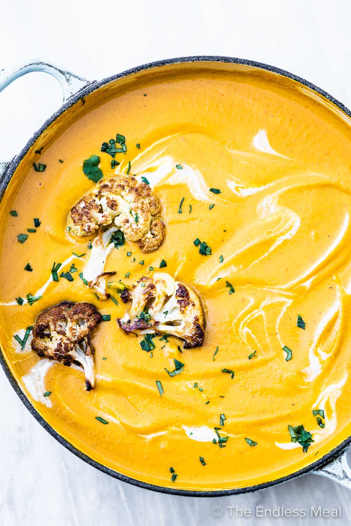 A pot of bright yellow curried cauliflower soup.