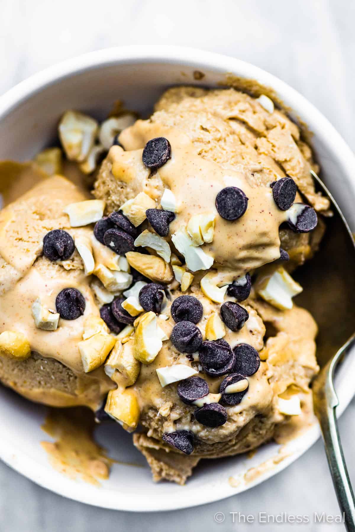 A spoon taking a scoop of banana peanut butter ice cream.