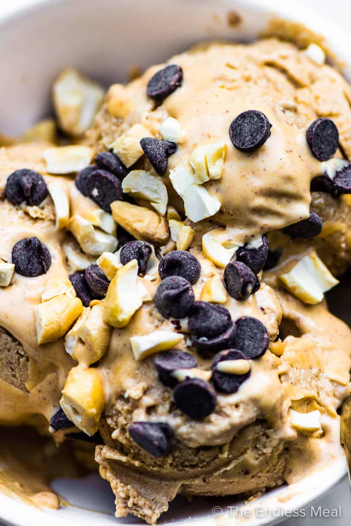 A close up of banana peanut butter ice cream in a bowl with chocolate chips on top.