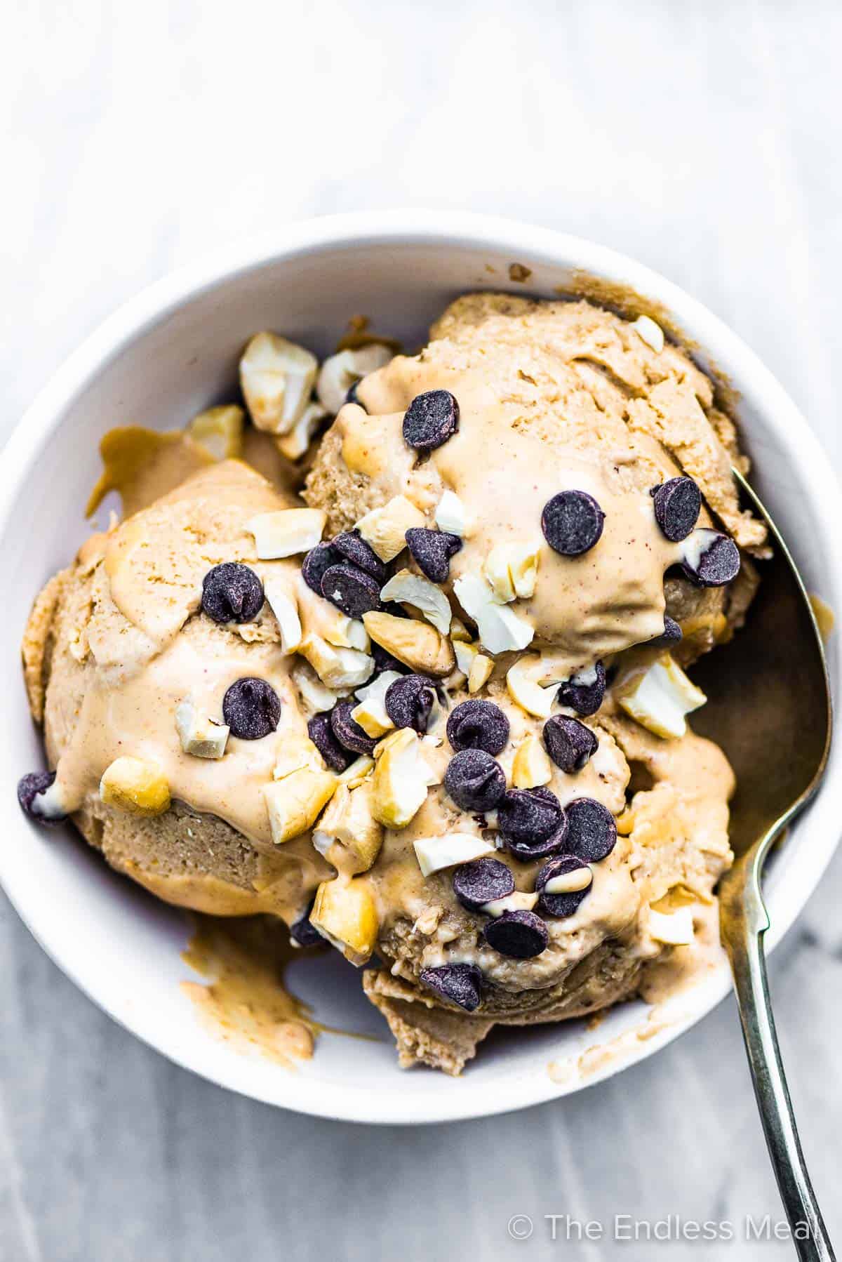 A white bowl filled with peanut butter banana ice cream and chocolate chips on top.