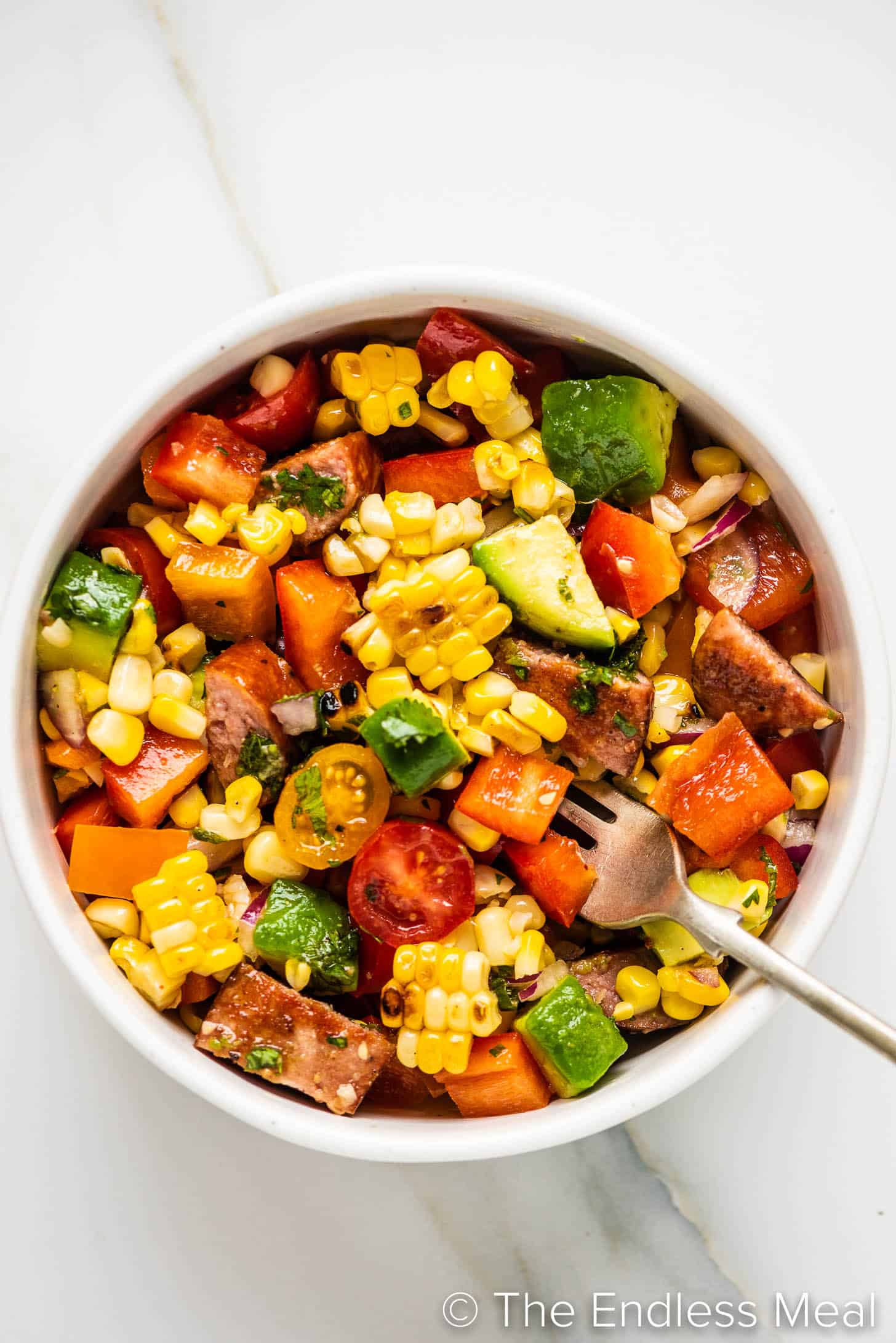 a bowl of Grilled Corn Salad with a fork