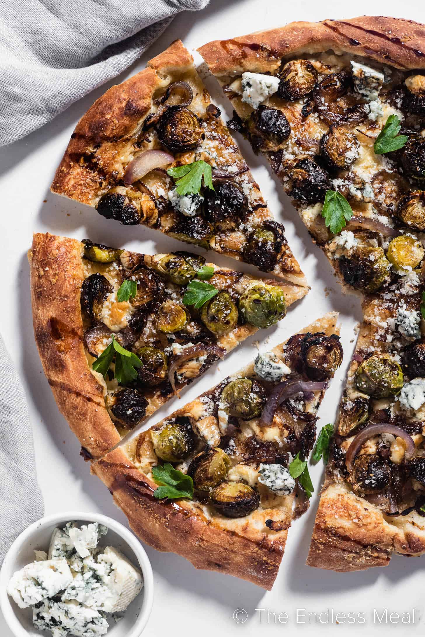 a close up of pizza topped with brussels sprouts