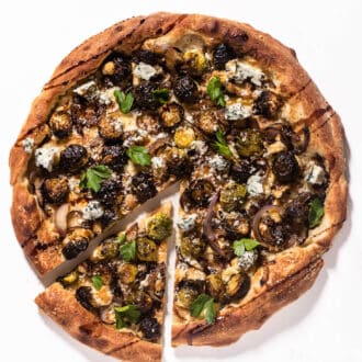 A Brussels Sprouts Pizza with a slice out of it