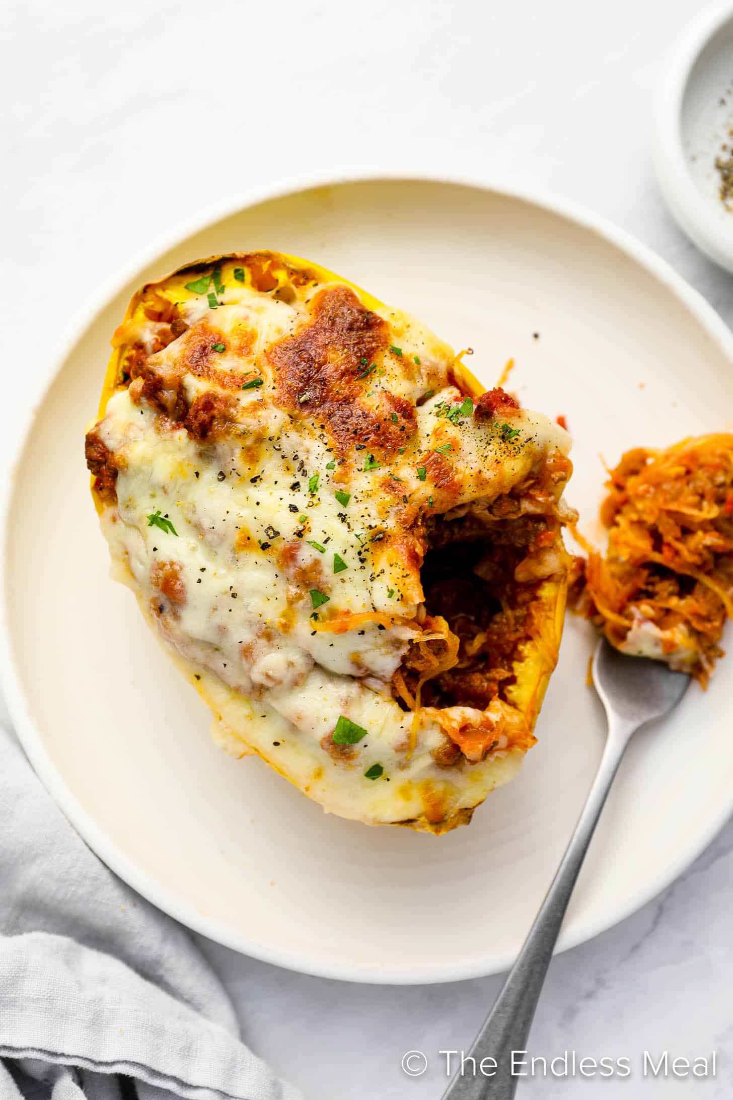A fork scooping some Spaghetti Squash Lasagna out of the squash shell