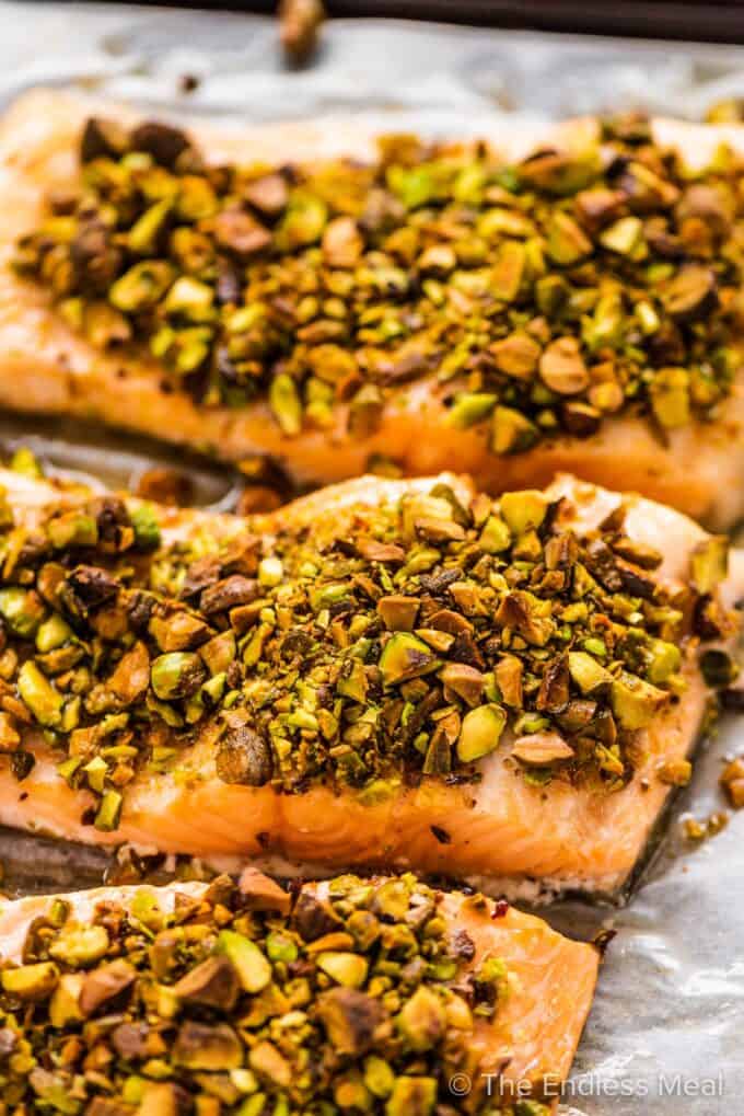 A close up of pistachio crusted salmon on a baking tray.