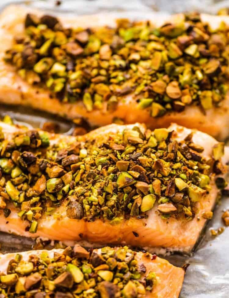 A close up of pistachio crusted salmon on a baking tray.