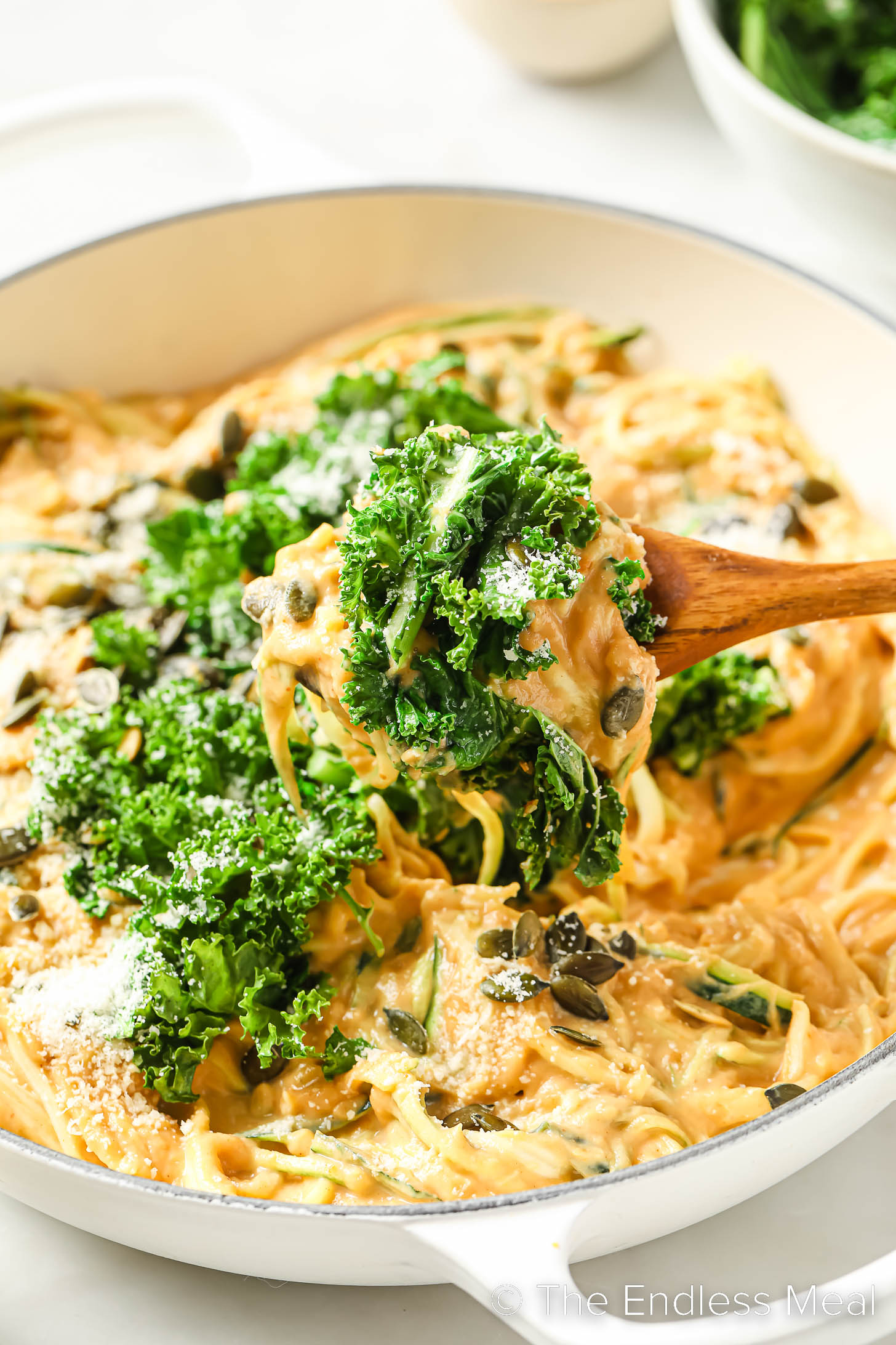 Healthy Pumpkin Alfredo in a pan with a wooden spoon