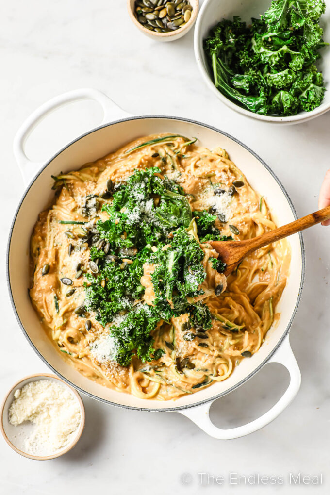 looking down on Healthy Pumpkin Alfredo in a pan topped with kale